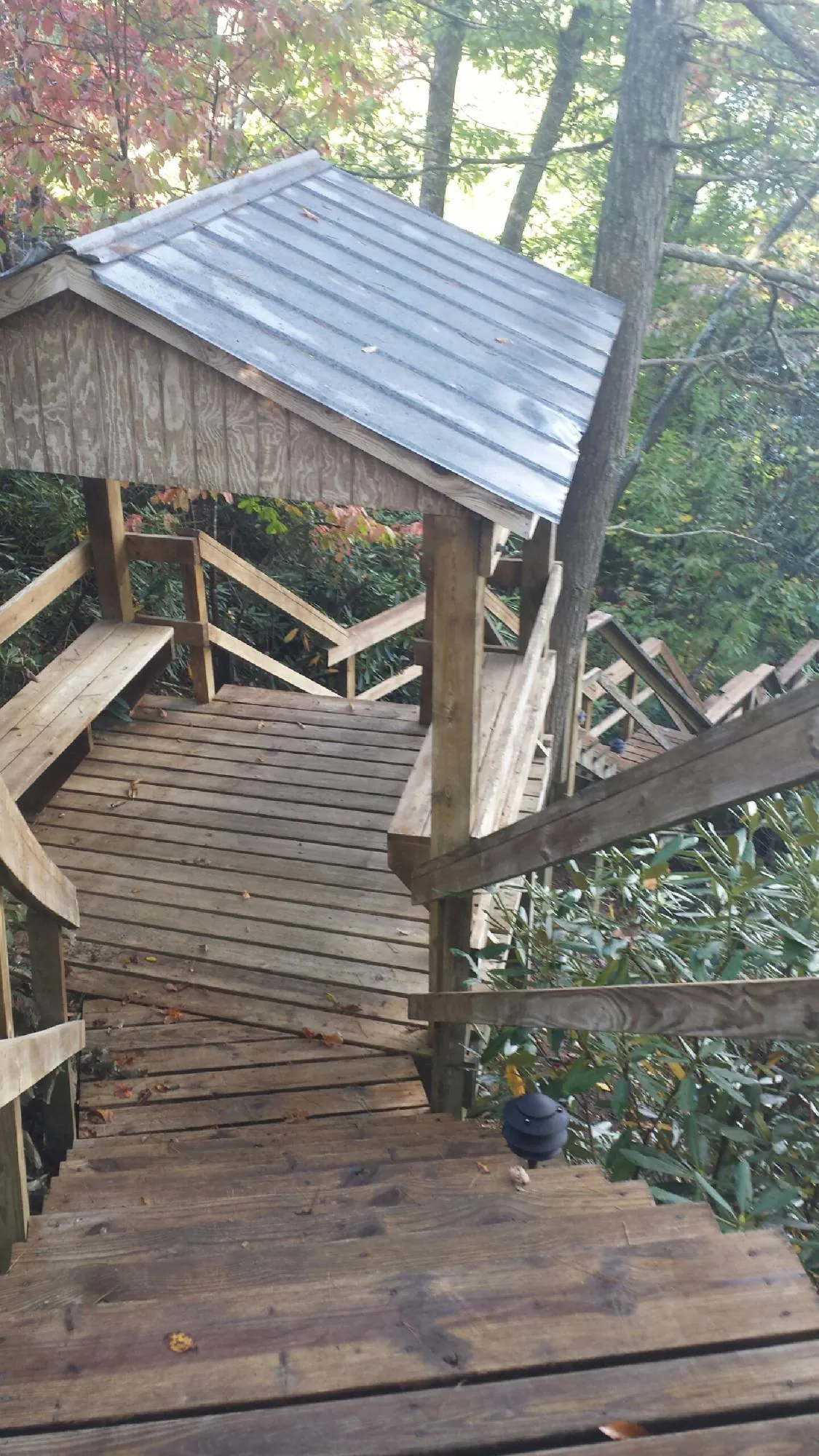 Metal roofed shelter over wooden steps on a wooded walkway — Skylight Repair & Installation work by our crew in Drexel