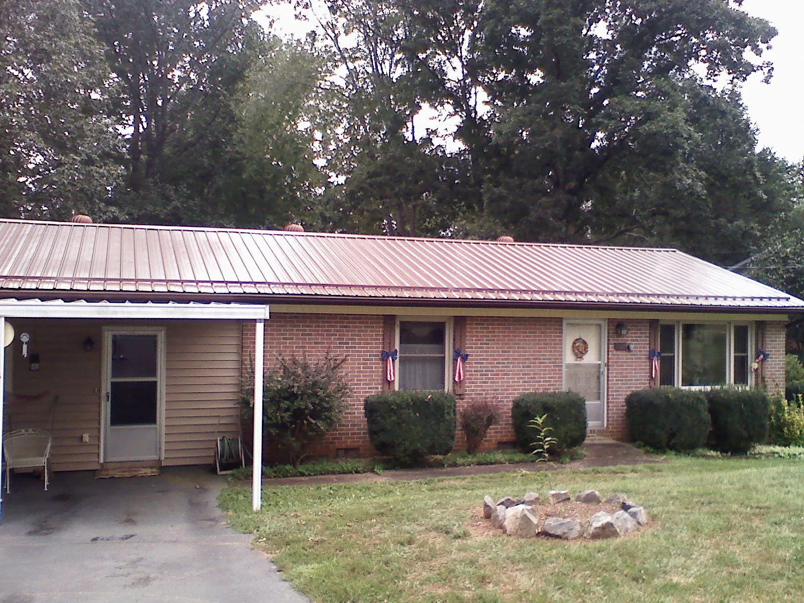 Bronze metal roof and carport on a brick ranch home — Roof Repair work by our crew in Drexel
